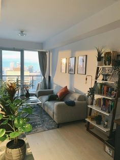 a living room filled with furniture and a large window overlooking the cityscape in front of it