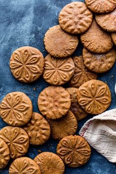 some cookies are on a blue surface and one has been cut in half to look like flowers