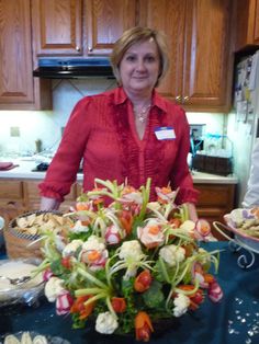 a woman standing in front of a table filled with food