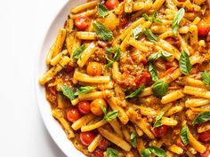 pasta with tomatoes and basil in a white bowl