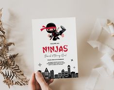 a person holding up a card with a ninja on it