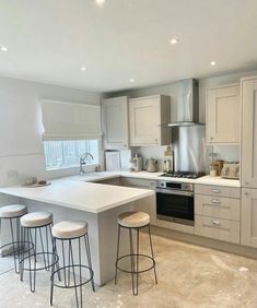 a kitchen with white counter tops and stools