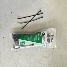 two screwdrivers are laying on the ground next to a pack of nails