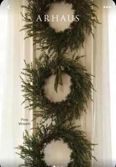 the front door is decorated with wreaths and greenery for holiday decor, like this one in arhaus's home