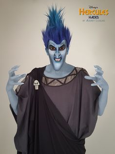 a man with blue hair and makeup is dressed up as he appears to be an evil villain