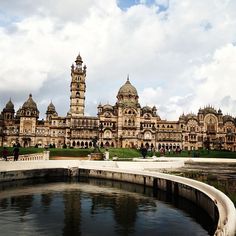 a large building with many towers on top of it's sides and water in the foreground