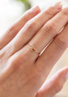 Love knot rings have a deep history throughout the ages and throughout various parts of the world. This dainty ring is a simplified version, and features a minimalist knot, perfect for stacking or to be worn on it's own.  Made from 14/20 gold-filled wire, it is water-resistant and will be a piece that lasts. Each piece is custom-made for you, so please allow 1-5 days for the jewelry to ship. - 14/20 Gold Filled  - 1.1mm band - Handmade to order - Comes neatly packaged in a kraft jewelry box read Knot Rings, Dainty Promise Ring, Gold Knot Ring, Aesthetic Doctor, Love Knot Ring, Zierlicher Ring, Knot Ring, Gold Filled Ring, Love Knot