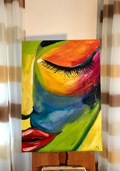 an abstract painting with bright colors and large lashes is on display in front of curtains