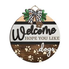 a wooden sign that says welcome hope you like dogs with paw prints and a bow