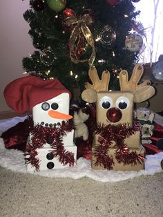 two snowmen made to look like they are standing in front of a christmas tree