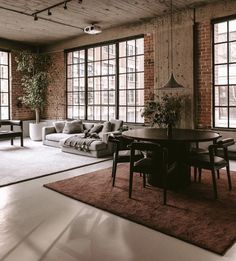 a living room filled with furniture and large windows