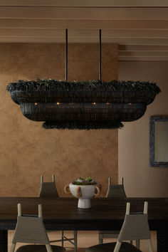 a dining room table with chairs and a bowl on it's centerpiece hanging from the ceiling