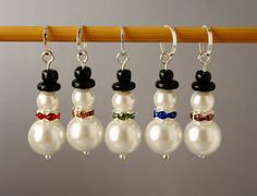 six snowmen wearing hats and bow ties are hanging from a clothes line with beads