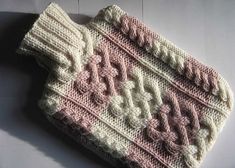 a pink and white crocheted purse sitting on top of a table