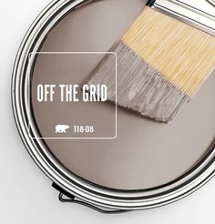 a paint can with the words off the grid painted on it and a brush inside