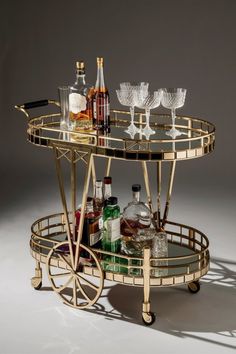 a bar cart with drinks and glasses on it