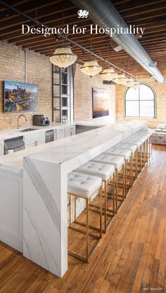 an open kitchen with marble counter tops and bar stools