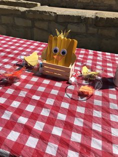 a red and white checkered table cloth topped with an egg carton cut out to look like a plant