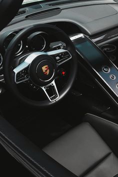 the interior of a sports car with steering wheel, dashboard and touchscreens showing