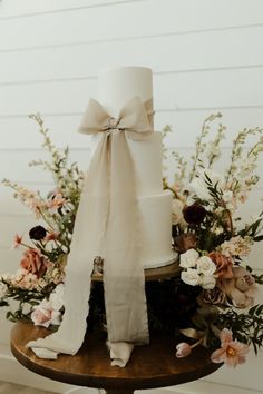 a white wedding cake sitting on top of a wooden table