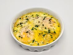 an egg dish in a white bowl with parsley on top