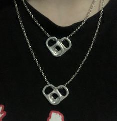 a close up of a person wearing a necklace with two interlocked links on it