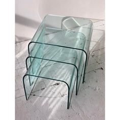 three glass tables sitting on top of each other in the middle of a white room