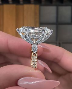 a woman's hand holding a diamond ring