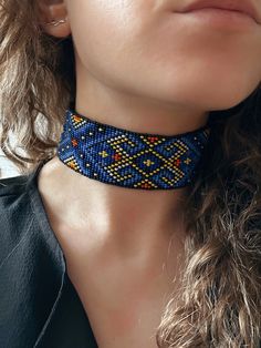 a woman wearing a blue and yellow beaded collar