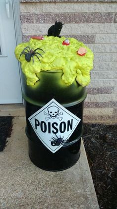 a black barrel with yellow frosting and decorations on the top that says poison