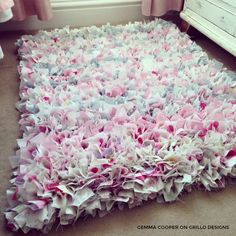 a pile of pink and white rag rugs on the floor in a living room