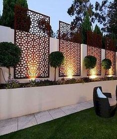 an outdoor seating area is lit up at night with lights shining on the walls and trees