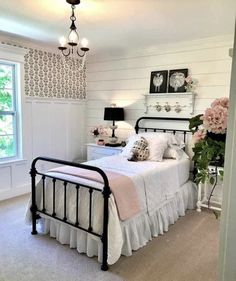 a bedroom with white walls and pink flowers on the nightstands in front of the bed