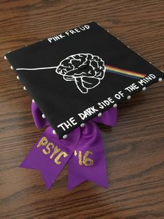 a graduation cap with the words pink floyd on it and a purple ribbon tied around it