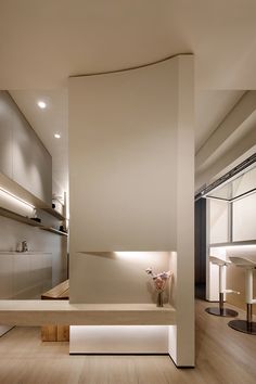 the interior of a modern house with wood flooring and white walls is lit by recessed lighting