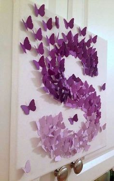 purple butterflies are arranged on a white wall