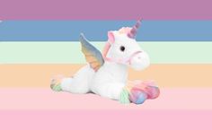 a stuffed unicorn sitting on top of a pink and blue striped background