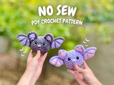 two small crocheted elephants are being held up