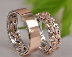 two gold wedding bands with diamonds on each one and an intricate design in the middle