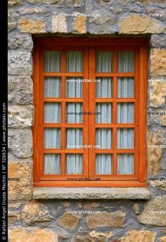 an old stone building with two wooden windows