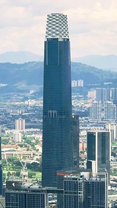 an aerial view of a city with skyscrapers in the foreground and mountains in the background