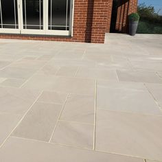 an outdoor patio with stone pavers and sliding glass doors on the side of it