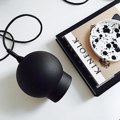 a black and white object sitting on top of a book next to a computer mouse