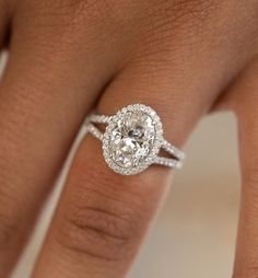 a close up of a person's hand with a diamond ring on their finger