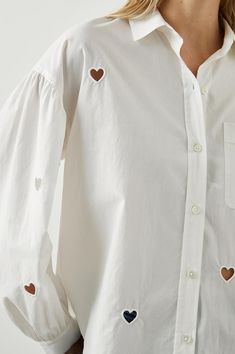 Made from lightweight cotton poplin, this button-down shirt comes in an oversized fit and features heart eyelets throughout, dropped shoulder, patch pocket at chest, and full sleeves with shirring.Oversized.55% Cotton, 45% Lyocell(Tencel)Hand wash cold, Hand dry, No Bleach, Cool iron if necessary or dry clean. Heart Shirt, White Eyelet, Denim Flares, Full Sleeves, Basic Tops, Style Board, Nice Tops, Cotton Poplin, Sweater Skirt