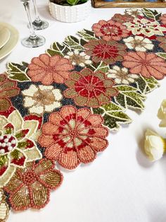 the table runner is decorated with flowers and leaves