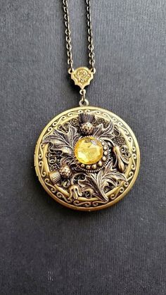 Large Flower Locket Necklace This necklace locket is bronze and copper, decorated with beautiful thistle flower that gives a vintage style cottage vibe. The piece is very involved and carefully made with a lot of detail. A lovely locket Necklace showcasing a yellow stone. See Photos for size comparison against American quarter Chain: ~ Antique Bronze Choose YOUR CHAIN LENGTH during checkout ☻More Lockets Here: https://www.etsy.com/shop/FashionCrashJewelry/search?search_query=lockets&order=date_d Luxury Vintage Round Pendant Locket Necklace, Antique Copper Locket Jewelry, Steampunk Medallion Engraved Jewelry, Steampunk Gold Jewelry With Antique Finish, Antique Gold Steampunk Jewelry As Gift, Antique Gold Steampunk Jewelry Gift, Antique Gold Steampunk Jewelry For Gift, Steampunk Antique Gold Jewelry Gift, Bronze Steampunk Jewelry With Engraving