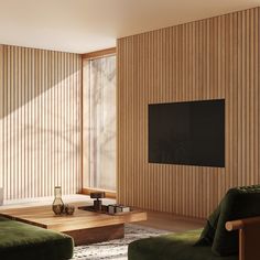 a living room with green couches and a flat screen tv mounted on the wall