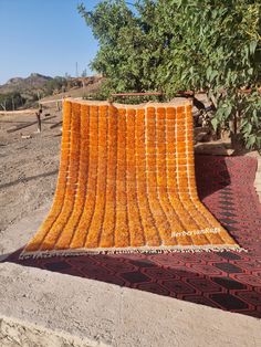 an orange blanket is laying on the ground