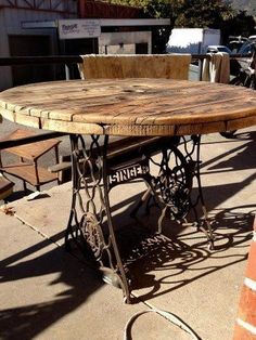 an old sewing table is sitting on the sidewalk